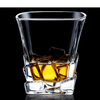 Faceted whisky glass with amber liquid, reflective vertical walls and stepped base