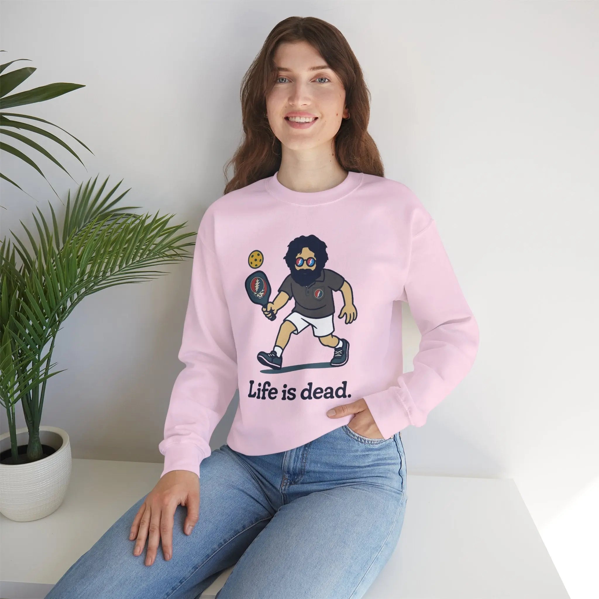 Light pink crewneck sweatshirt with cartoon character graphic and 'Life is dead,' modeled