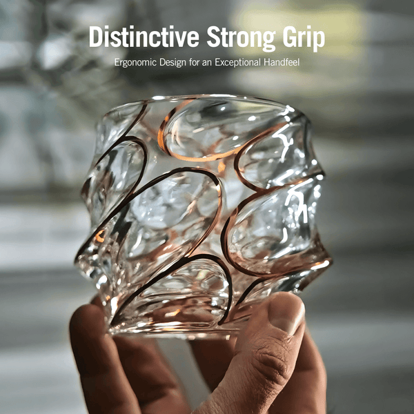 Japanese crystal whisky glass with gold line swirl pattern, held by hand