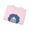 Light pink folded crewneck sweatshirt with blue face graphic and sunglasses print