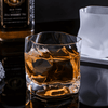 Hoshi crystal whisky glass with amber whisky, glossy facets and dark reflective background