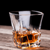 Clear faceted whisky glass with amber liquid pooling in square base