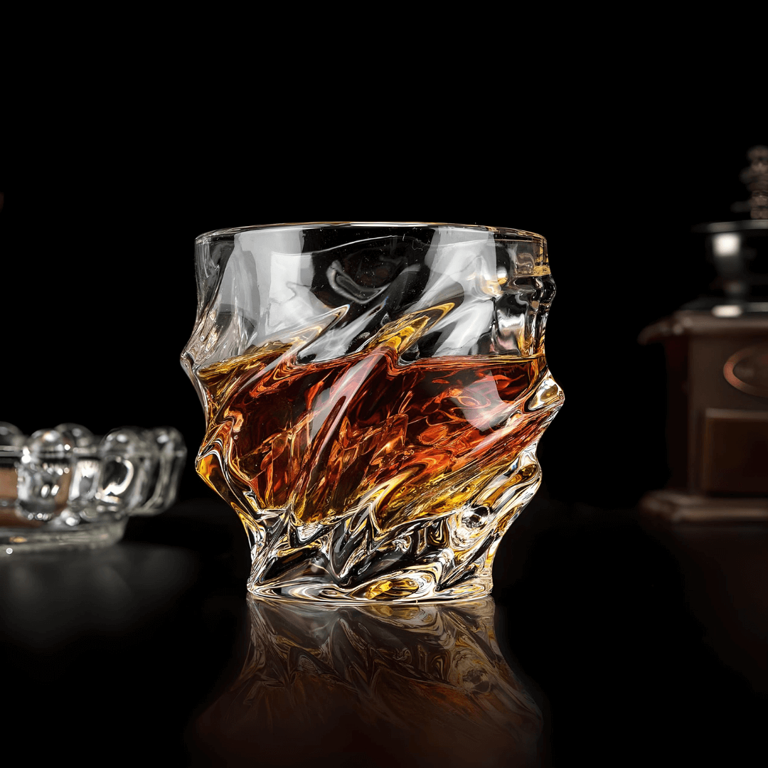 Crystal whisky glass with faceted wave pattern and thick rounded rim, amber reflections
