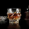Crystal whisky glass with faceted wave pattern and thick rounded rim, amber reflections