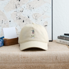 Khaki dad hat with embroidered golf character logo patch and curved brim