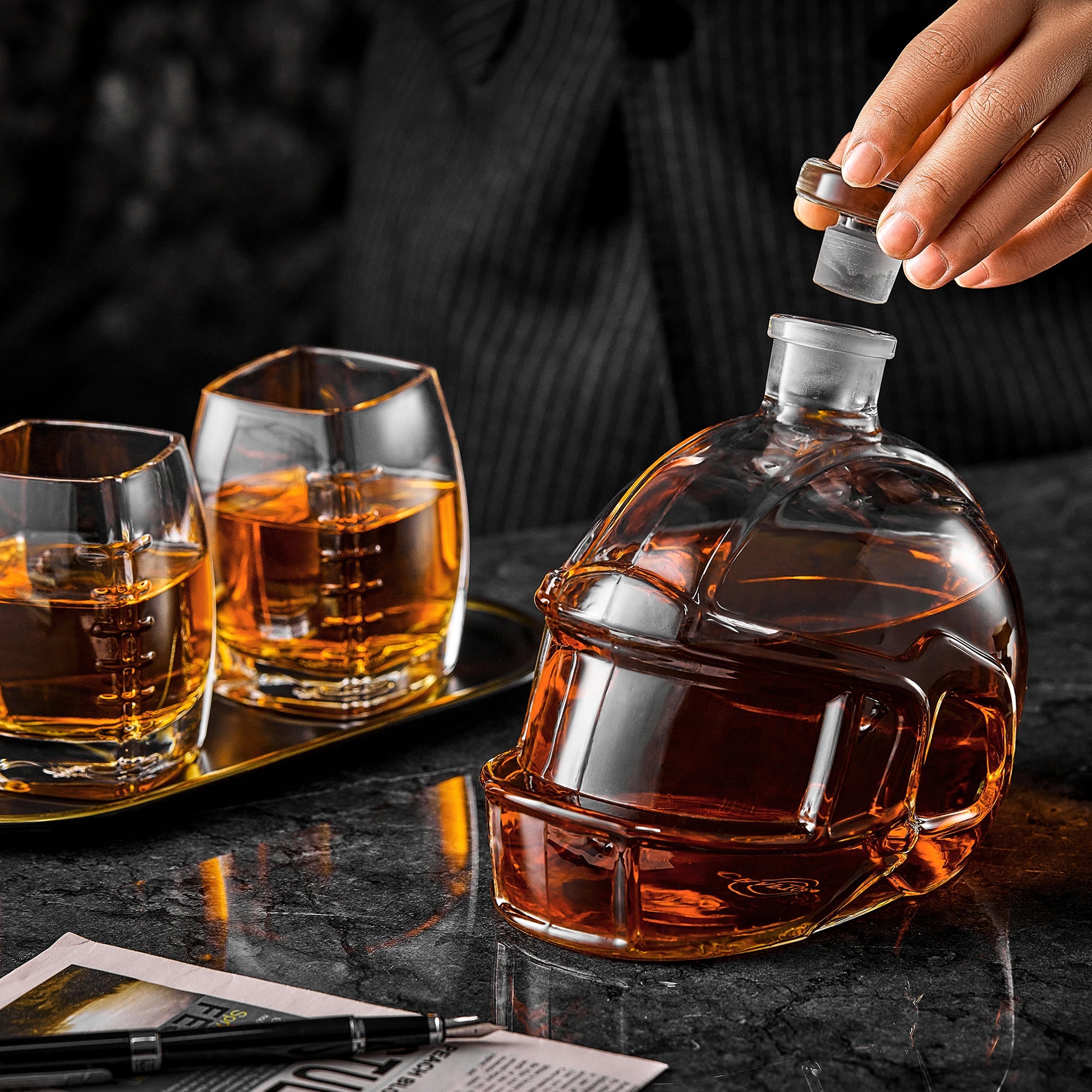 Football-shaped whiskey decanter with amber tumblers and poured glasses