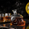 Close-up football-shaped whiskey decanter with amber tumblers