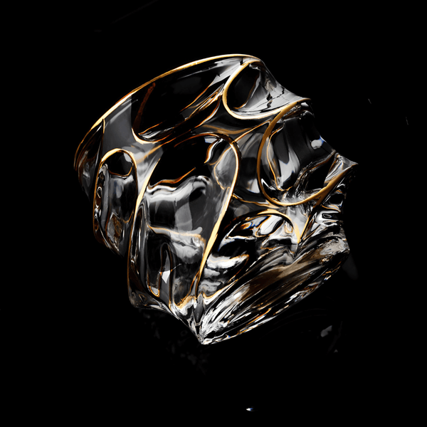 Crystal whisky glass with gold swirling line pattern, clear faceted sides