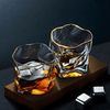 Set of two gold-rim whisky glasses on a wooden tray with amber liquid