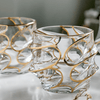Clear crystal whisky glass with gold swirl line design, thick faceted sides