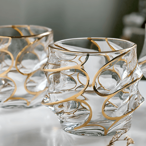Clear crystal whisky glass with gold swirl line design, thick faceted sides
