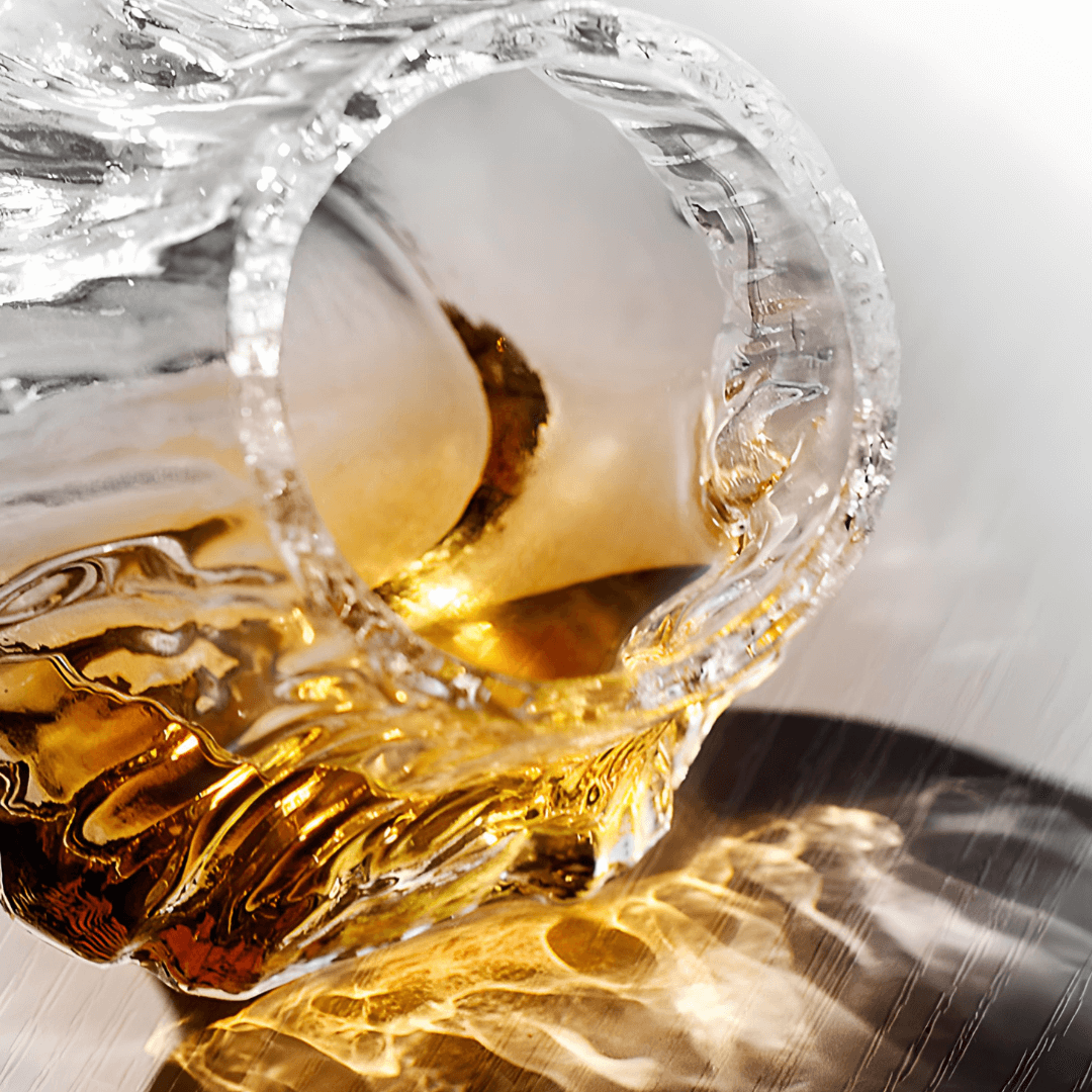 Japanese crystal whisky glass with swirling amber whisky splash through the rim