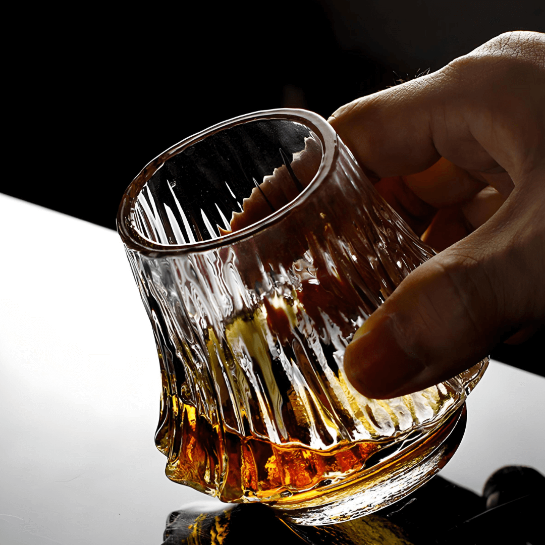 Japanese crystal whisky glass with amber base, hand gripping faceted sides