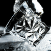 Crystal whisky glass close-up with star-cut facets and sharp geometric pattern