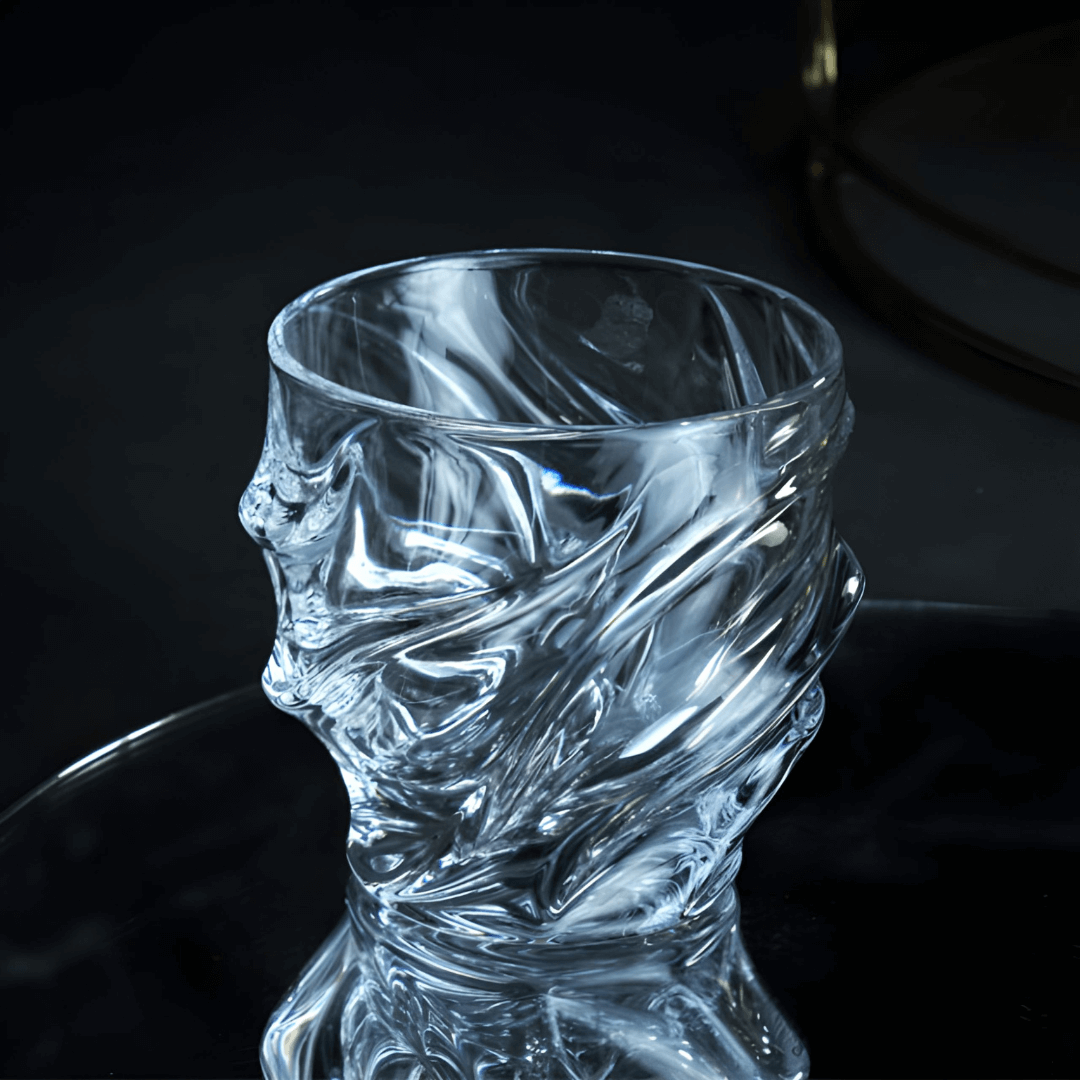Crystal whisky glass with faceted wave pattern and thick rounded rim, cool-toned