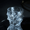 Crystal whisky glass with faceted wave pattern and thick rounded rim, cool-toned