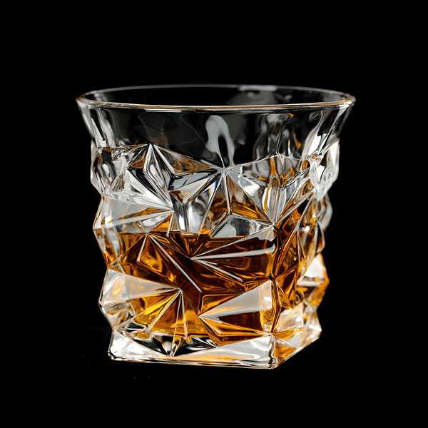 Crystal whisky tumbler with faceted geometric design, clear glass with amber tones