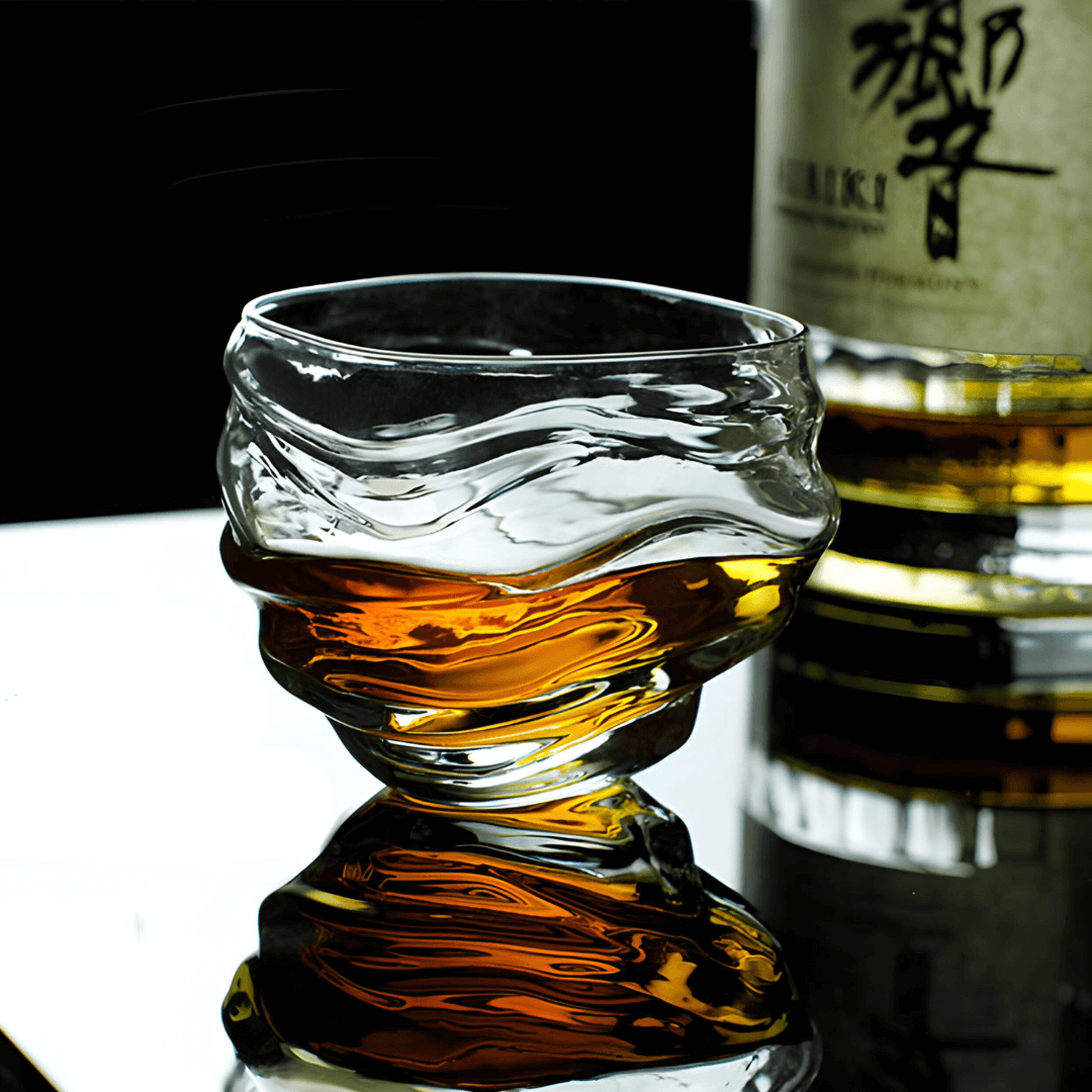 Crystal whisky glass with amber liquid, textured wavy pattern around bowl.