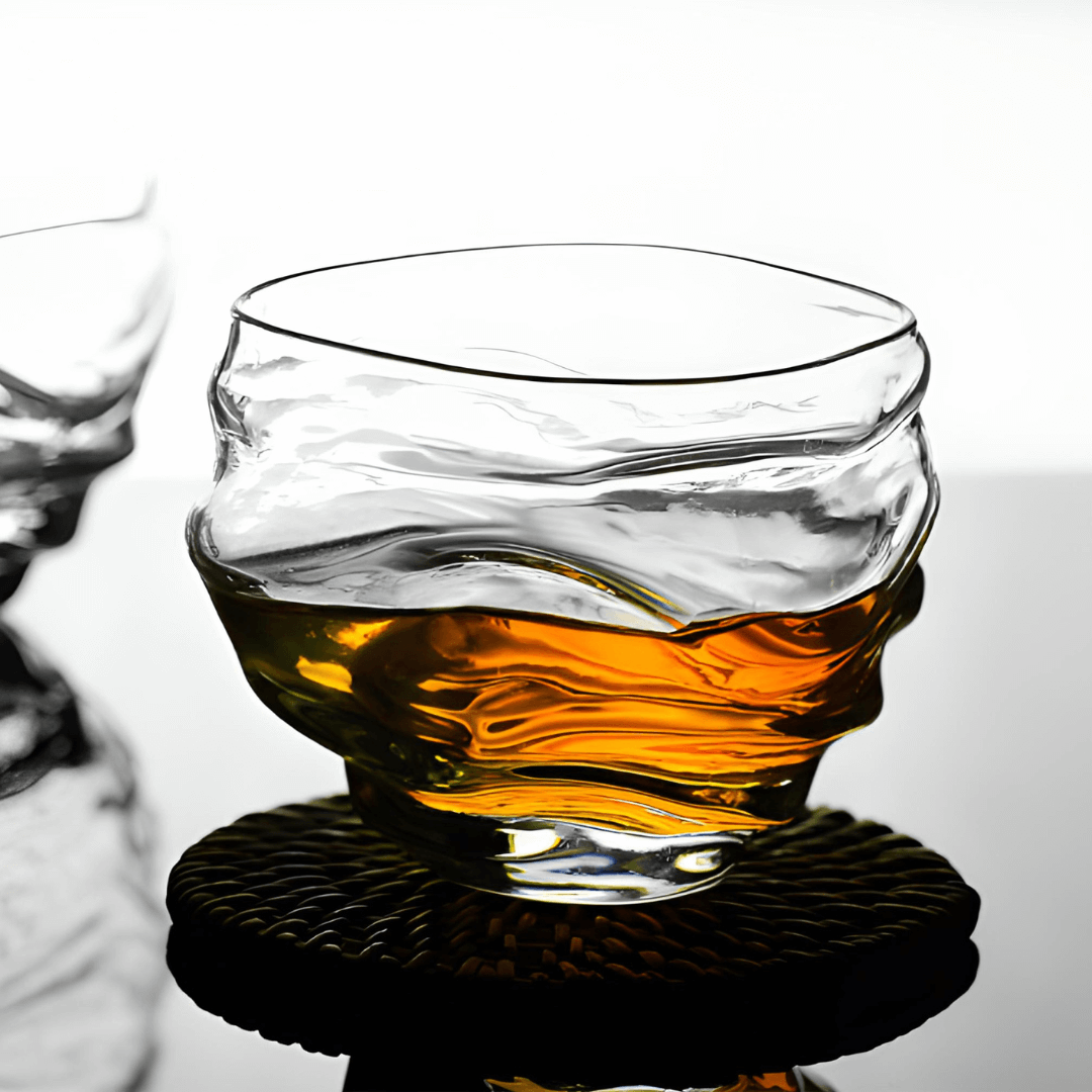 Crystal whisky glass with amber whisky, rounded rim and faceted base