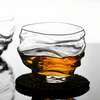 Crystal whisky glass with amber whisky, rounded rim and faceted base