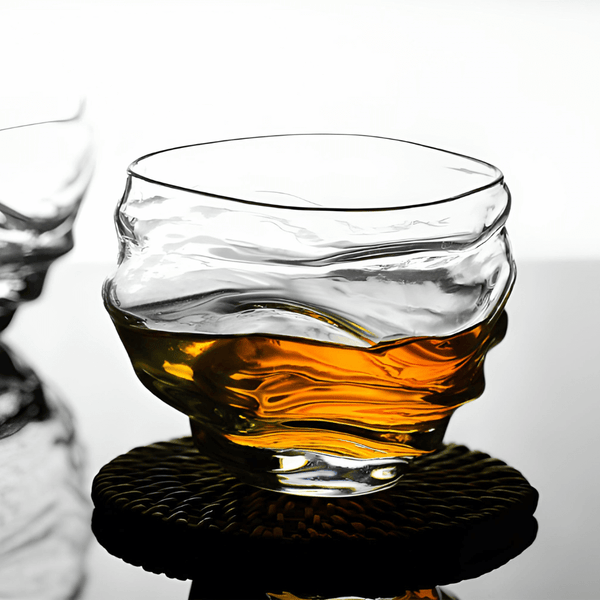 Crystal whisky glass with amber whisky, rounded rim and faceted base