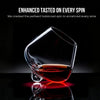 Crystal wine glass filled with red wine on reflective surface