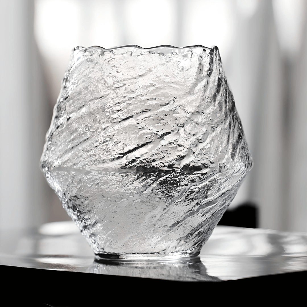Textured crystal whisky glass, clear finish, faceted irregular shape on tabletop