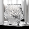 Textured crystal whisky glass, clear finish, faceted irregular shape on tabletop