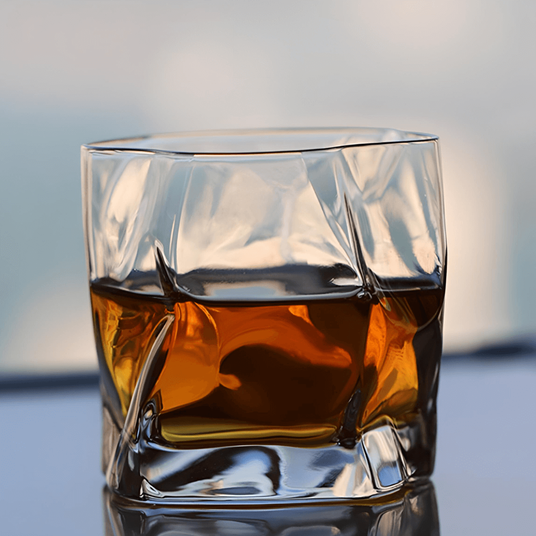 Hoshi Japanese crystal whisky glass filled with amber whisky, straight front view