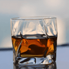 Hoshi Japanese crystal whisky glass filled with amber whisky, straight front view