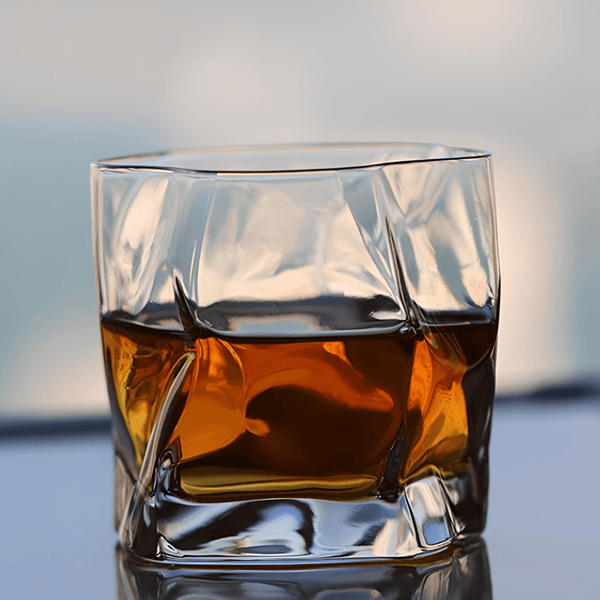 Hoshi Japanese crystal whisky glass filled with amber whisky, straight front view