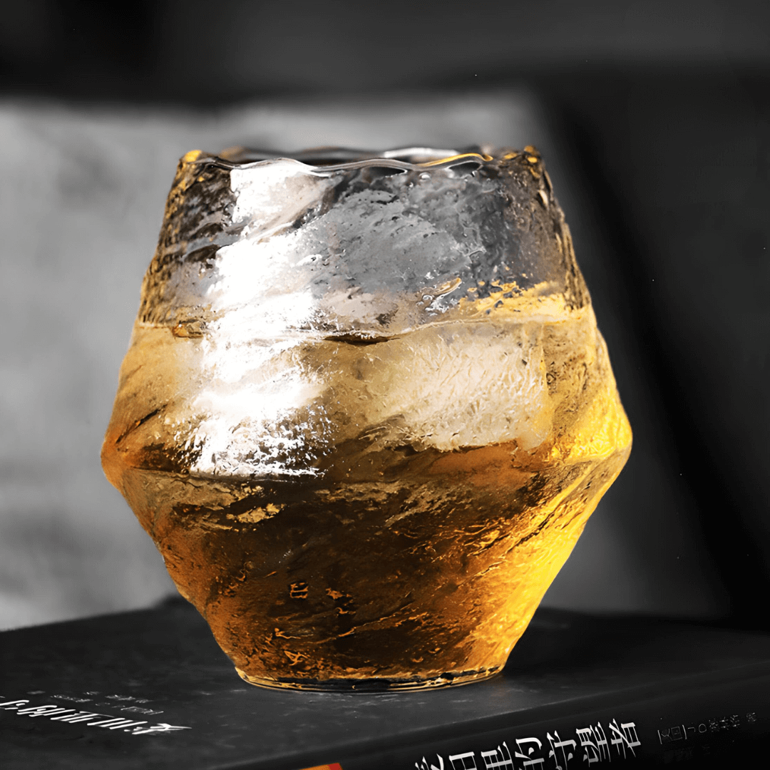 Textured crystal whisky glass with warm amber tint and faceted irregular surface