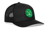 Black mesh trucker cap with green crossed clubs front patch and curved brim.