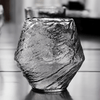 Textured crystal whisky glass, clear with dark reflections, faceted irregular shape
