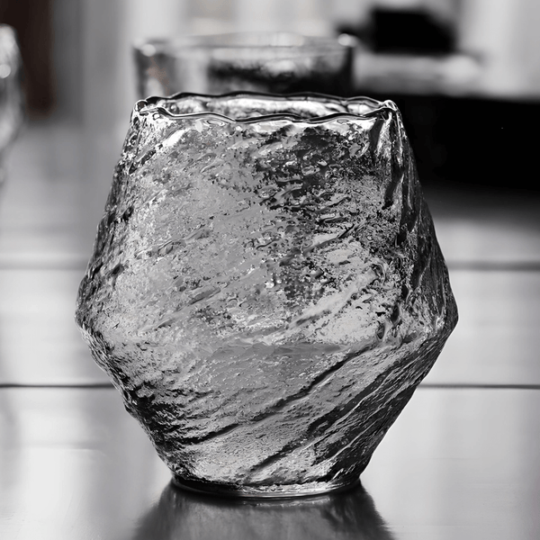 Textured crystal whisky glass, clear with dark reflections, faceted irregular shape