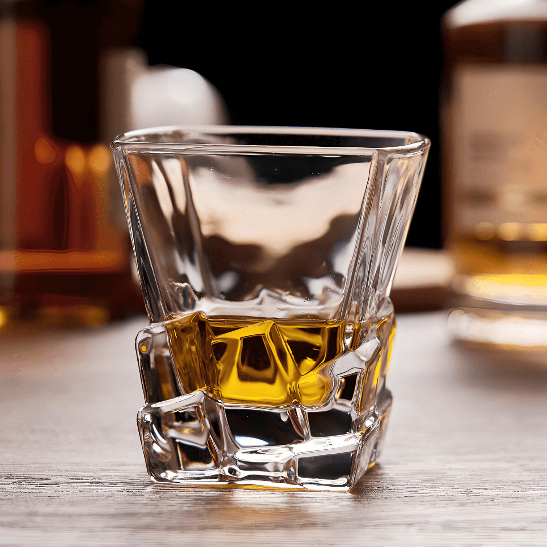 Faceted whisky glass with amber liquid, thick crystal base and side facets
