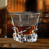 Faceted whisky glass with amber liquid, square cut base and angled sides