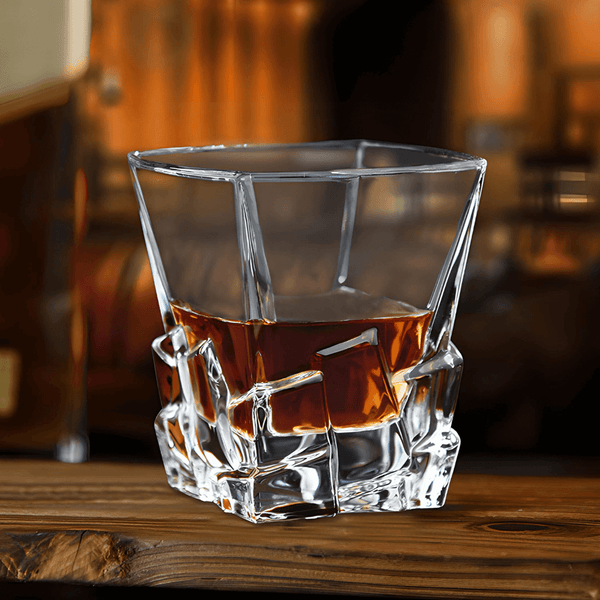 Faceted whisky glass with amber liquid, square cut base and angled sides