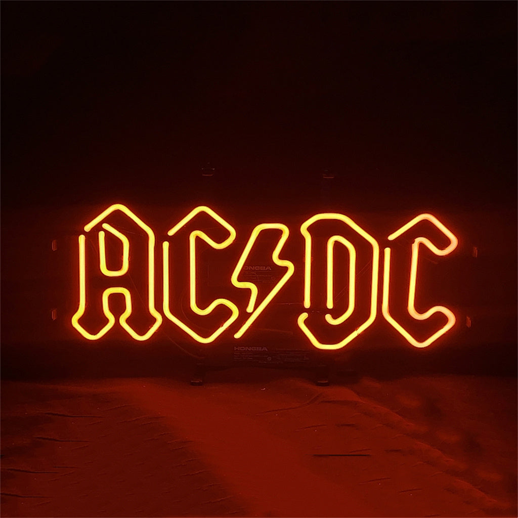AC/DC neon sign with glowing yellow-orange 'AC/DC' letters