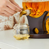 Hands pouring whiskey from spigot into a small glass jar