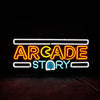 Neon sign “ARCADE STORY” with white tubing, orange/yellow letters, blue ghost.