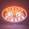 Neon oval sign showing Auburn tiger logo and 'AUBURN TIGERS' text, orange glow