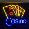 Mounted neon poker sign with yellow outlined cards and blue “Cisino” lettering