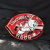 Cincinnati Reds neon sign with bat-and-baseball character, red glow and white lettering