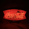 Neon light sign with red "Drink Coca Cola" script on shield backing on stand