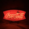 Neon light sign with red "Drink Coca Cola" script on shield backing