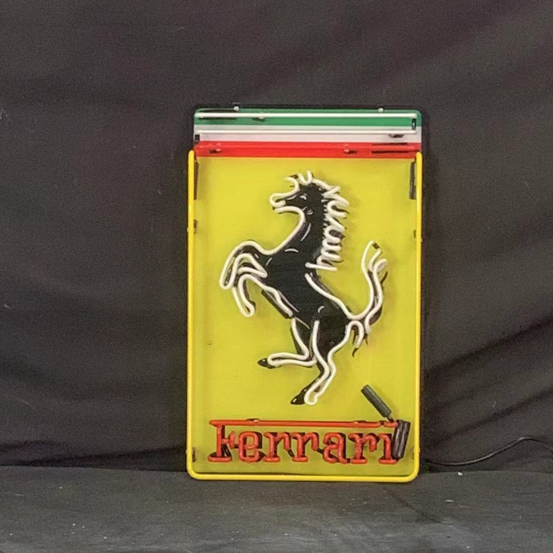 Rectangular Ferrari neon logo sign with prancing horse and Ferrari wordmark, on stand