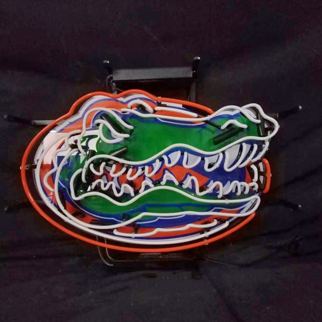 Neon alligator face sign with green head, blue stripes, and orange outer border, metal mount