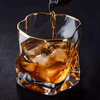 Gold-rim crystal whisky glass with faceted sides and amber drink
