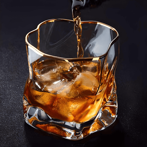 Gold-rim crystal whisky glass with faceted sides and amber drink